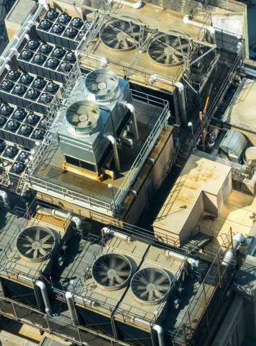 High-angle shot of HVAC units on a city building's rooftop, showcasing industrial infrastructure.